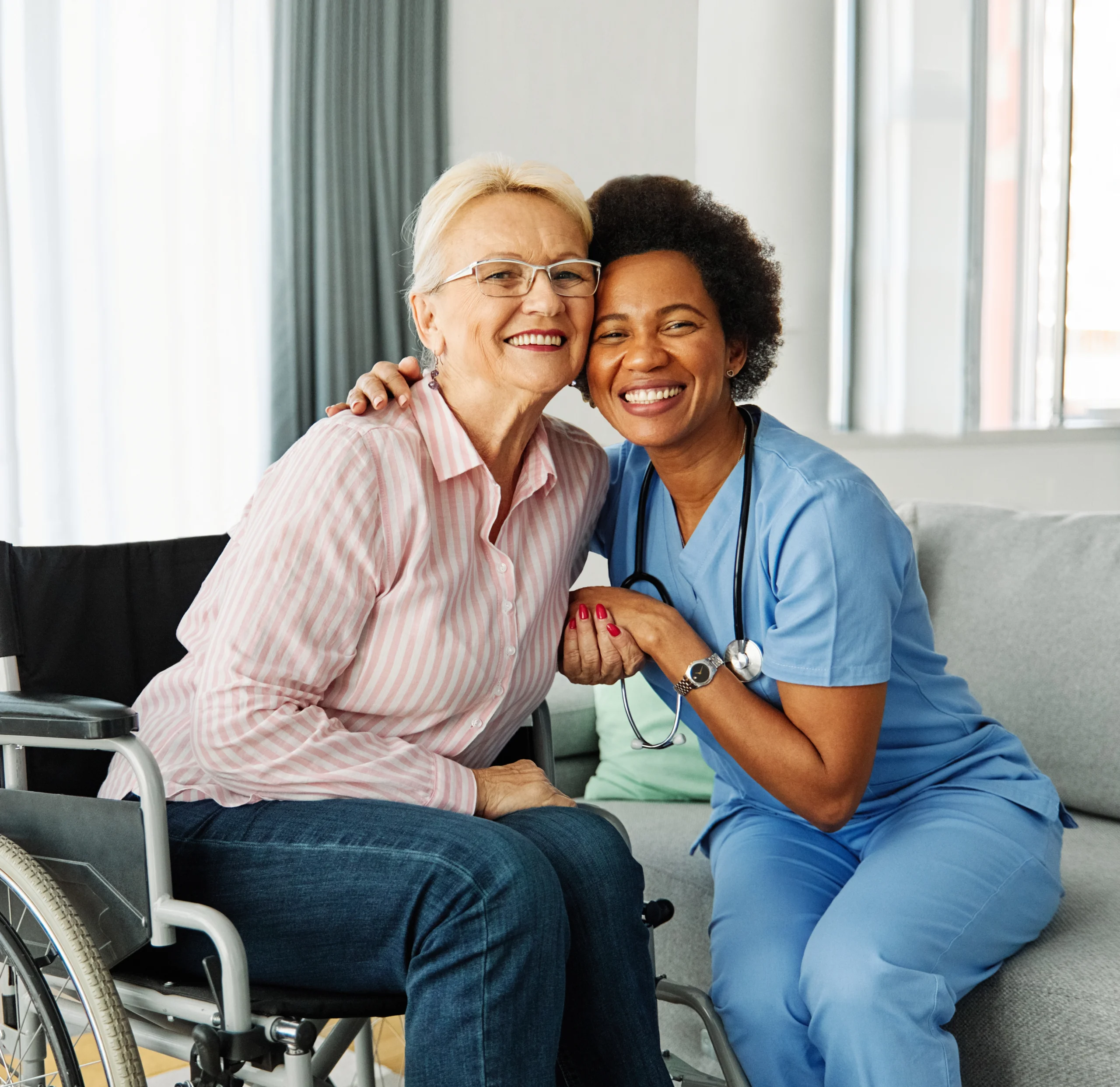 friendly woman hugging senior woman in wheelchair