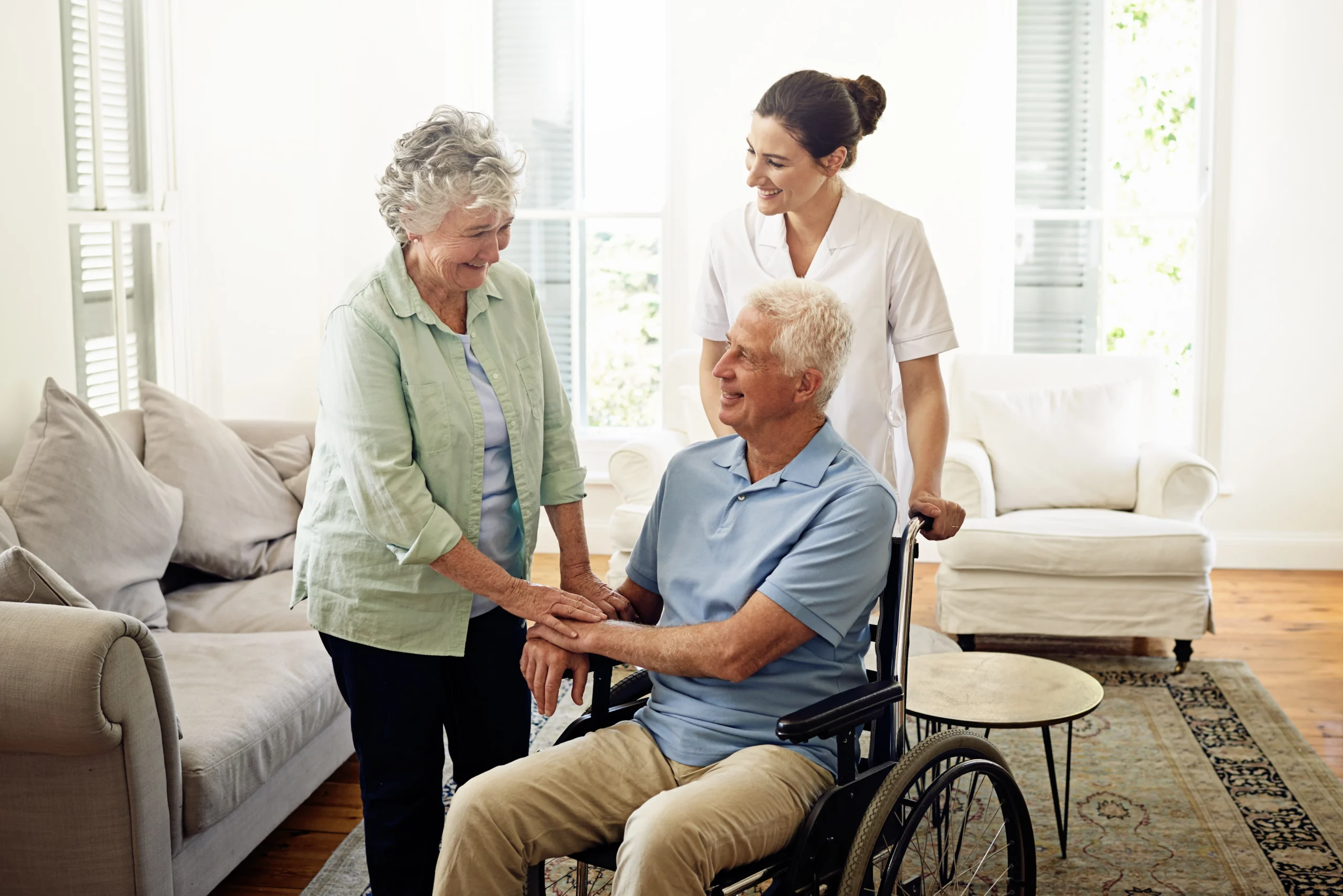 man in wheelchair shakes caregiver's hand