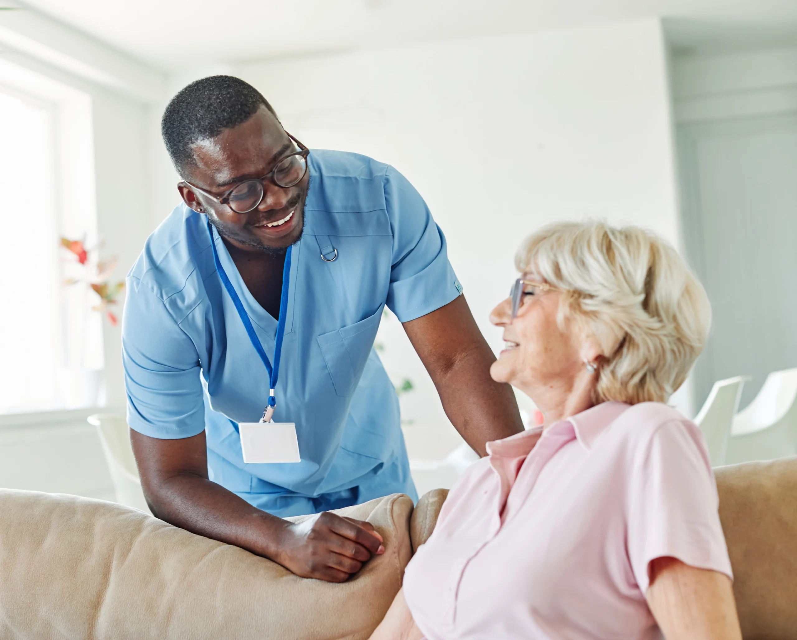 African american nurse checking on aged blonde lady