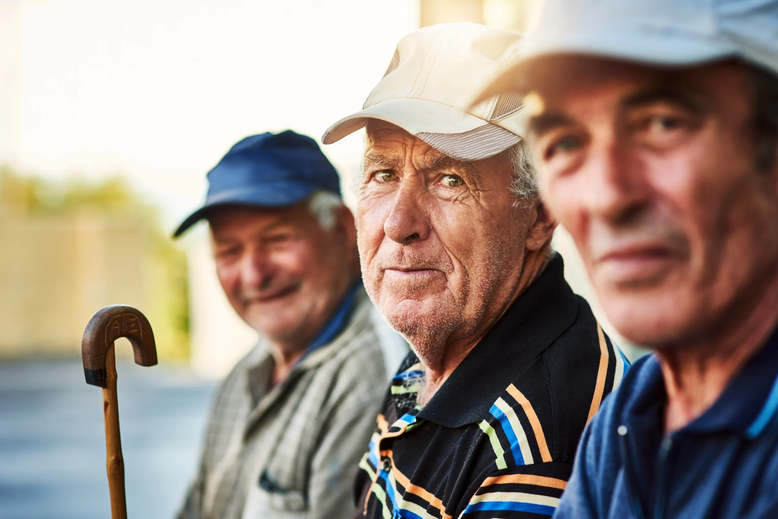 three elderly veterans sitting outside