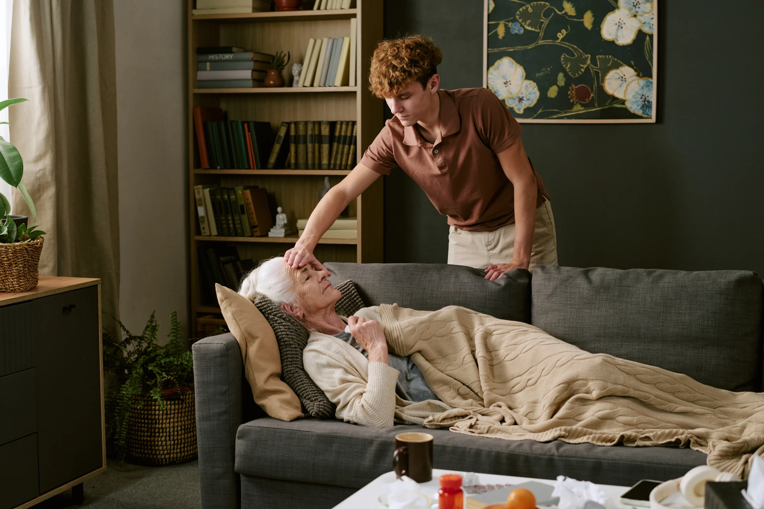 young man checks forehead tempreture of elderly woman